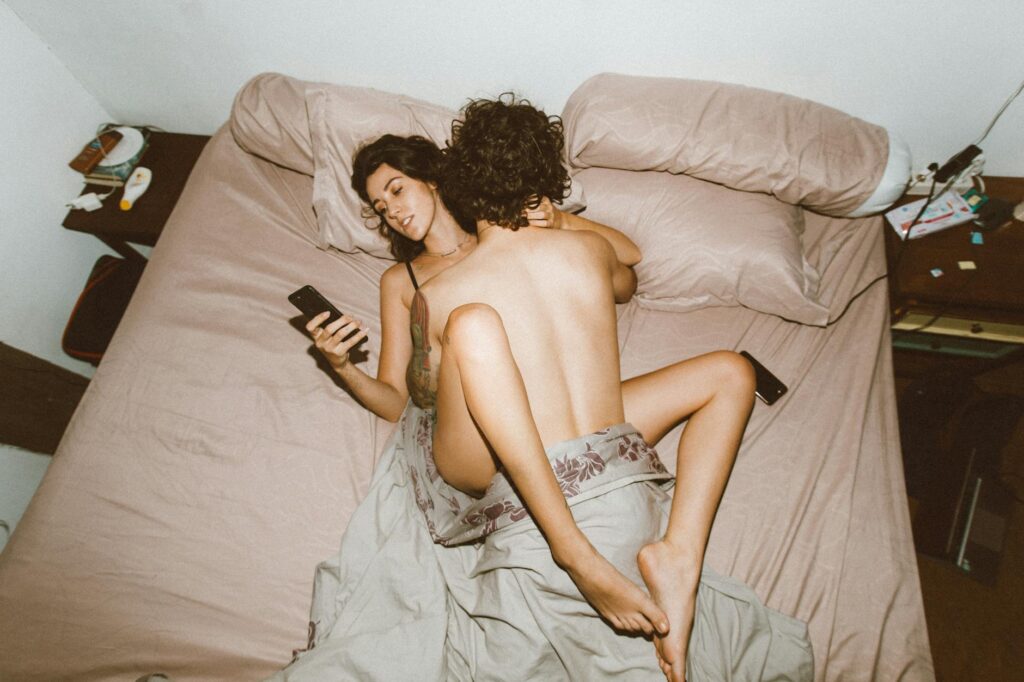 couple being intimate and using smartphone